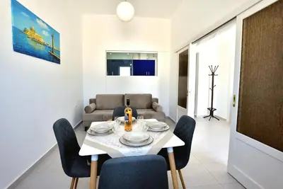 a dining room with a table and chairs and a couch at Athina's house in Archangelos