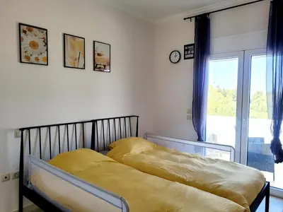 a bedroom with a bed with yellow sheets and a window at Villa Maritsá in Pastida