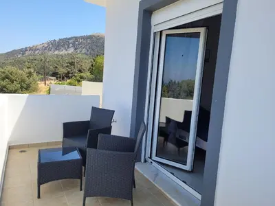 a balcony with chairs and a table with a view at Villa Maritsá in Pastida