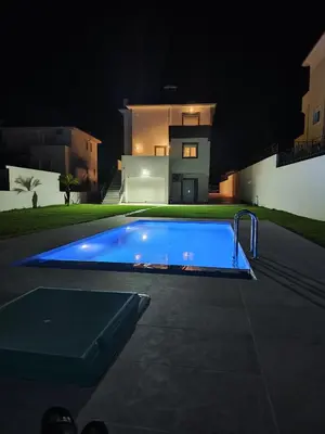 a swimming pool in front of a house at night at Villa Maritsá in Pastida