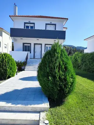 a white house with a blue roof at Villa Maritsá in Pastida