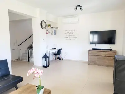 a living room with a tv on a white wall at Villa Maritsá in Pastida