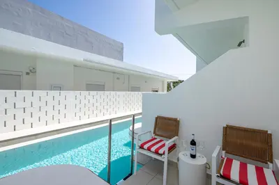 a balcony with two chairs and a swimming pool at Patricia Suites in Faliraki