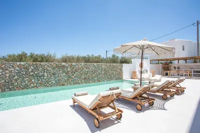 a pool with chaise lounge chairs and an umbrella at Zaia Suites & Living , Suite N6 , sea side view in Gennadi