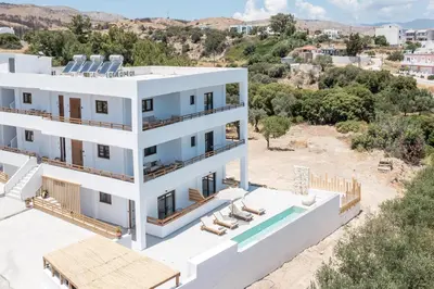 an aerial view of a white building with a swimming pool at Zaia Suites & Living , Suite N6 , sea side view in Gennadi