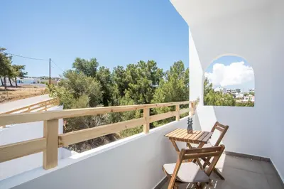 a room with a balcony with two chairs and a table at Zaia Suites & Living , Suite N6 , sea side view in Gennadi