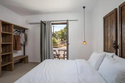 a bedroom with a white bed and a table at Zaia Suites & Living , Suite N6 , sea side view in Gennadi