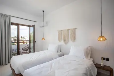 two beds in a hotel room with white sheets at Zaia Suites & Living , Suite N6 , sea side view in Gennadi