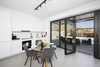 a kitchen and dining room with a table and chairs at Villa 13 Zendo in Kolimbia