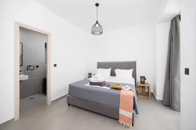 a bedroom with a large bed and a bathroom at Villa 13 Zendo in Kolimbia