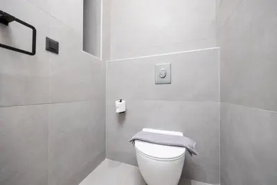 a bathroom with a white toilet with a towel on it at Villa 13 Zendo in Kolimbia