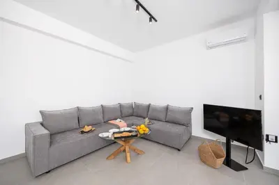 a living room with a gray couch and a table at Villa 12 Chado in Kolimbia