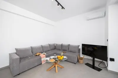 a living room with a gray couch and a table at Villa 10 Hozan in Kolimbia