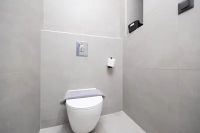 a bathroom with a white toilet with a towel on it at Villa 10 Hozan in Kolimbia