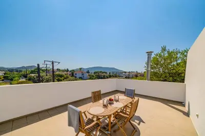 a patio with a table and chairs on a balcony at Villa Thalassa Ixia by Villa Plus in Ialyssos