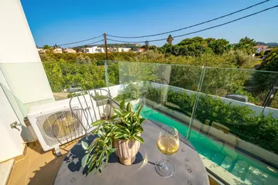 a table with glasses and a plant on a balcony at Villa Thalassa Ixia by Villa Plus in Ialyssos
