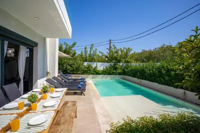 a patio with a table and chairs next to a swimming pool at Villa Thalassa Ixia by Villa Plus in Ialyssos