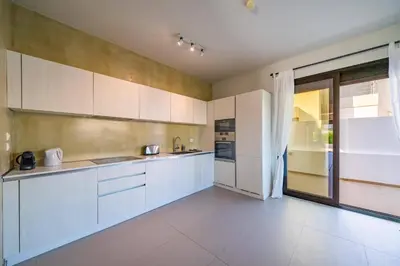 a kitchen with white cabinets and a large window at Villa Thalassa Ixia by Villa Plus in Ialyssos