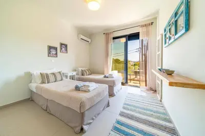 a living room with two beds and a couch at Villa Thalassa Ixia by Villa Plus in Ialyssos