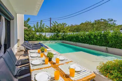 a patio with a table and a swimming pool at Villa Thalassa Ixia by Villa Plus in Ialyssos