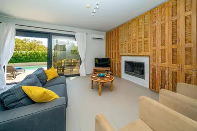 a living room with a blue couch and a fireplace at Villa Thalassa Ixia by Villa Plus in Ialyssos