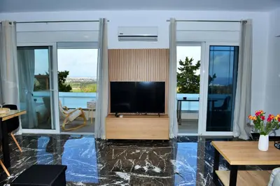 a living room with a flat screen tv on the wall at Aikaterini Lever Du Soleil Apart, Koskinou in Koskinou