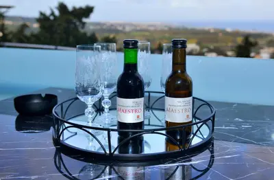 two bottles of wine and glasses on a table at Aikaterini Lever Du Soleil Apart, Koskinou in Koskinou
