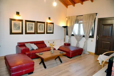 a living room with a red couch and a table at Unique Smaragda's Residense in Rhodes Town
