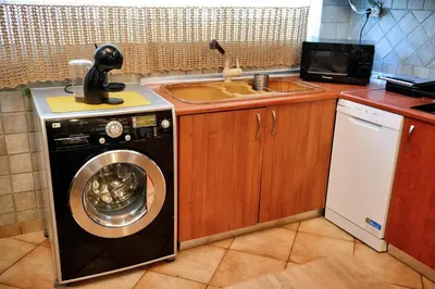 a kitchen with a washing machine and a sink at Unique Smaragda's Residense in Rhodes Town