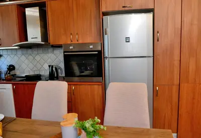a kitchen with a refrigerator and a table with chairs at Unique Smaragda's Residense in Rhodes Town