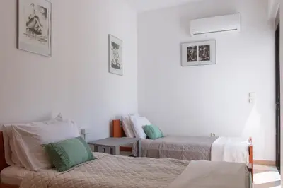 a white room with two beds and a table at Gallery7B in Ialyssos