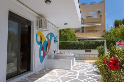 a white building with a mural on the side of it at Gallery7B in Ialyssos