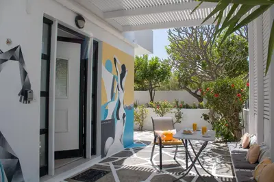 a patio with a table and chairs next to a door at Gallery7B in Ialyssos
