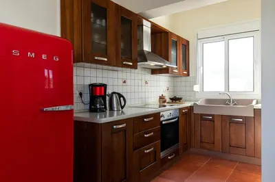 a kitchen with wooden cabinets and a red refrigerator at Elena House in Gennadi