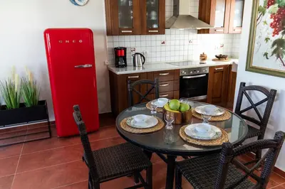 a kitchen with a table with chairs and a red refrigerator at Elena House in Gennadi