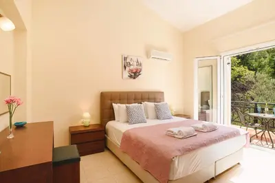 a bedroom with a bed and a balcony at Seven Springs Villas in Kolimbia