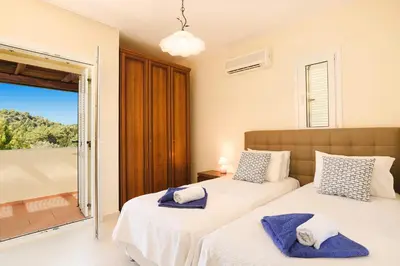 two beds in a bedroom with a balcony at Seven Springs Villas in Kolimbia