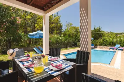 a table on a patio with a view of a pool at Seven Springs Villas in Kolimbia