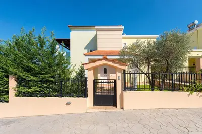a white house with a gate and a fence at Seven Springs Villas in Kolimbia