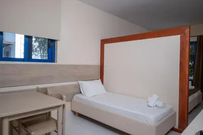 a small room with a bed and a table at Triantafillas Suites in Afantou