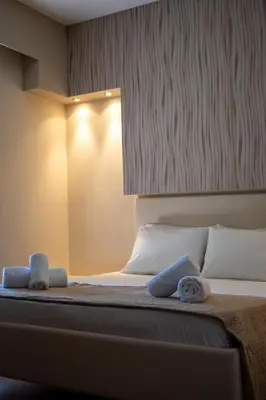 a bedroom with a bed with two towels on it at Triantafillas Suites in Afantou