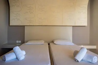 two beds sitting next to each other in a room at Triantafillas Suites in Afantou