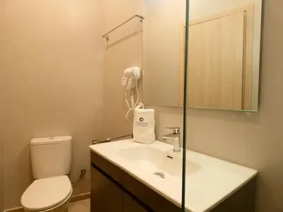 a bathroom with a sink and a toilet and a phone at Louloudi Hills Villa 3 in Koskinou