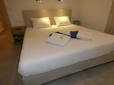 a white bed with two towels and a bow tie on it at Louloudi Hills Villa 3 in Koskinou