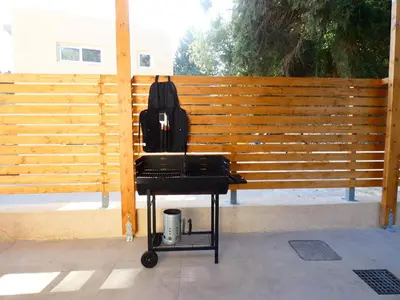 a black chair with a backpack on it next to a wooden fence at Louloudi Hills Villa 3 in Koskinou
