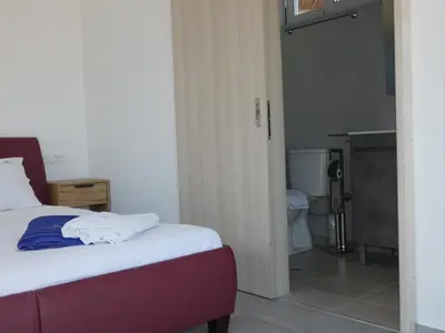 a bedroom with a bed and a bathroom with a toilet at Louloudi Hills Villa 3 in Koskinou