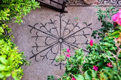 a drawing of a mandala on the ground next to flowers at Villa Melograno HALKI in Halki