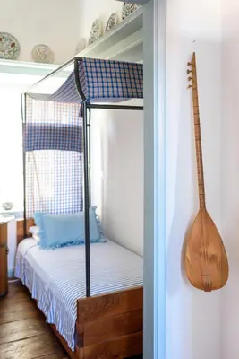a bedroom with a bed with a guitar on the wall at Villa Melograno HALKI in Halki