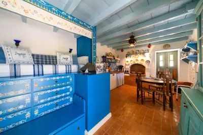 a room with blue cabinets and a dining room at Villa Melograno HALKI in Halki