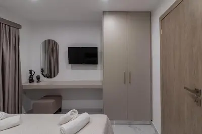 a bedroom with a bed and a cabinet with a television at Melia Luxury Villa in Kolimbia